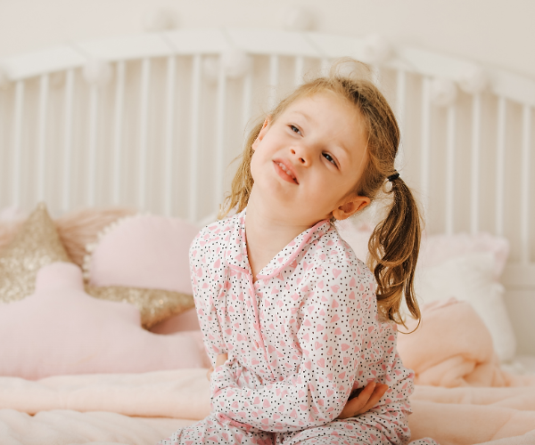 Child appears to be experiencing discomfort, head tilted sideways and hand on stomach.