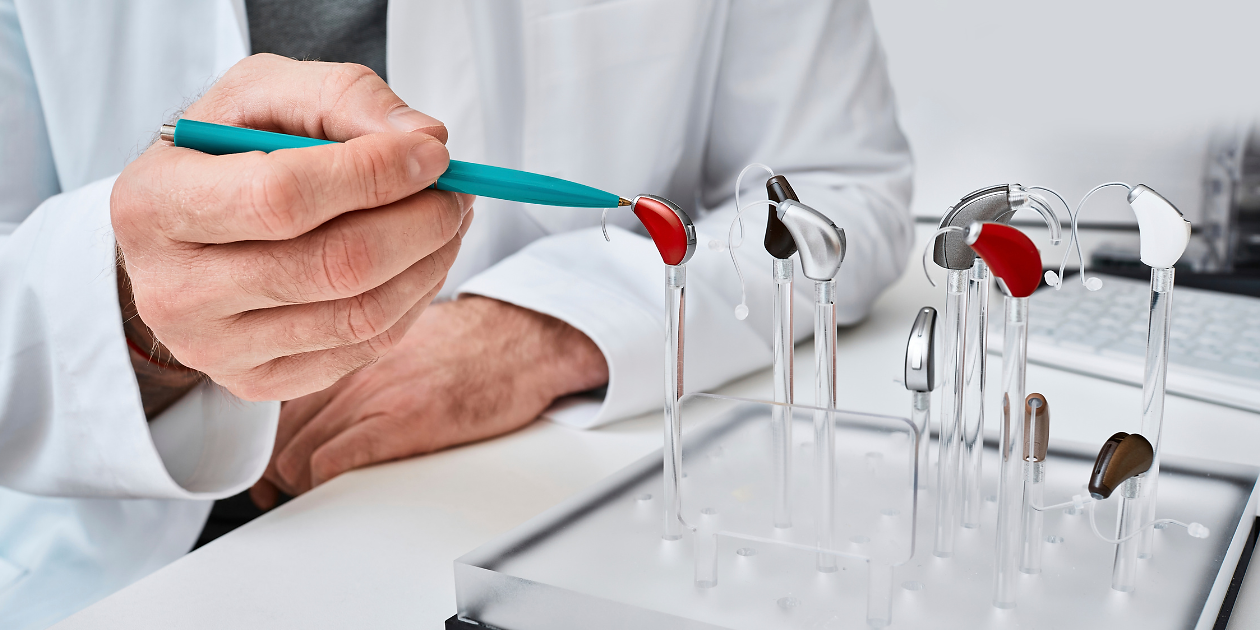 Doctor presenting hearing aid options; OTC Hearing Aids Show Promise in Clinical Effectiveness Trial