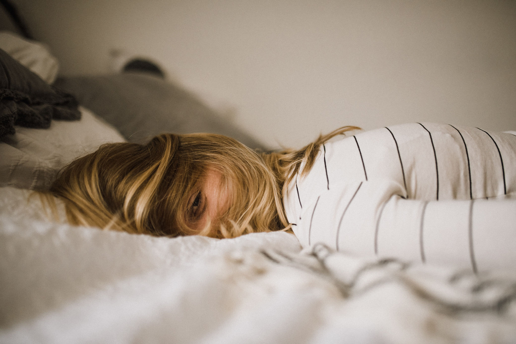 Woman laying tired in bed.