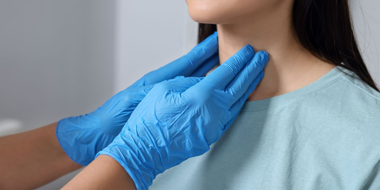 Doctor examining patient's thyroid glands